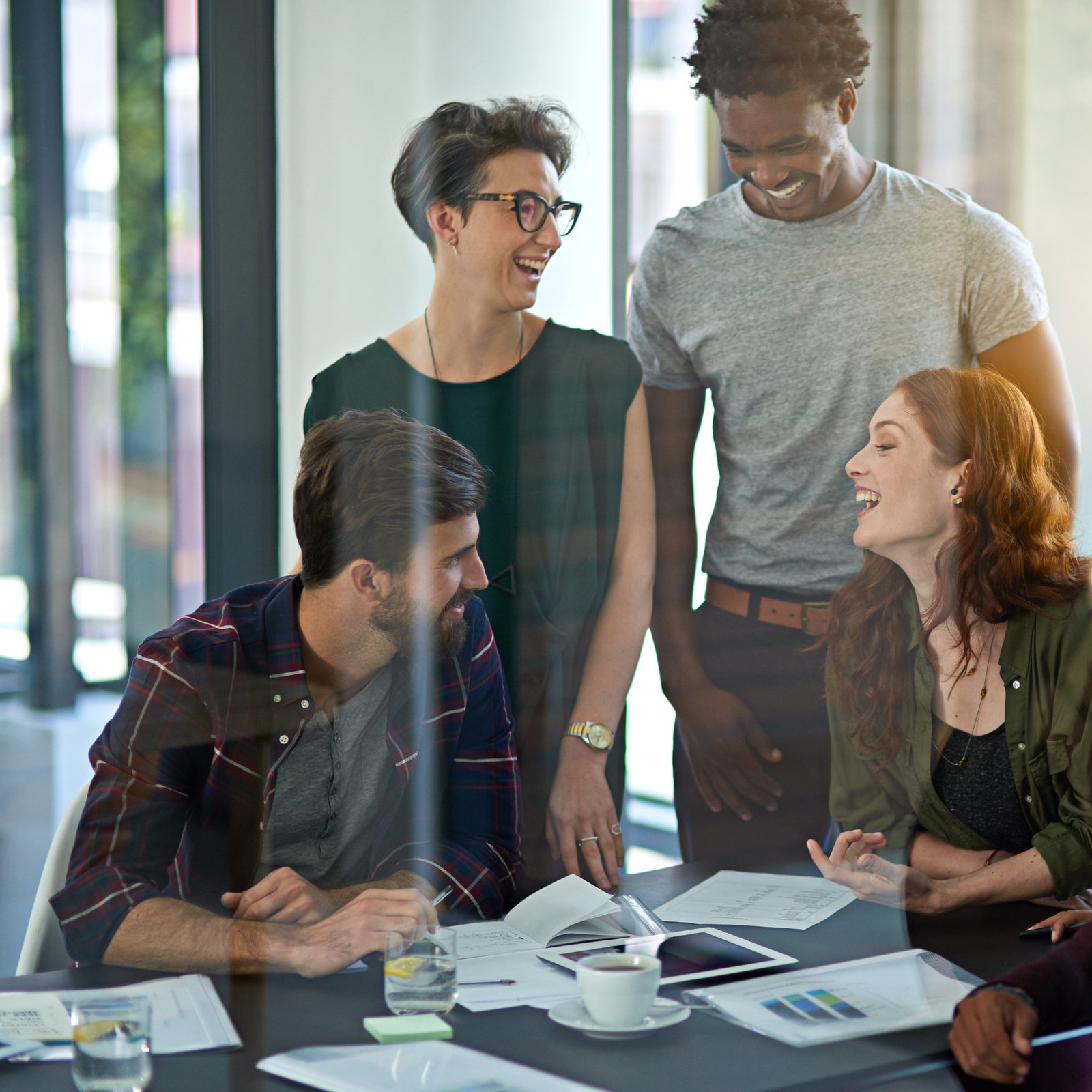 Cropped shot of a group of creatives working together on a digital tablet in a modern office